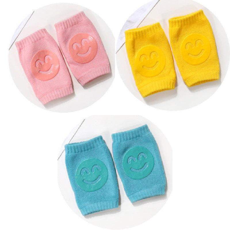Set of colorful baby knee pads with smiley face design on a white background