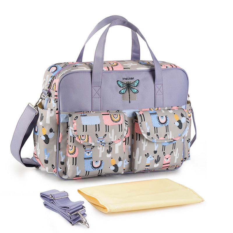 Multifunctional diaper bag with dragonfly design on a white background