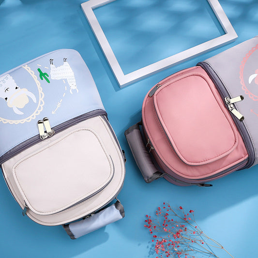 Two insulated travel bags, one white and blue and the other one pink and grey, on a blue surface.