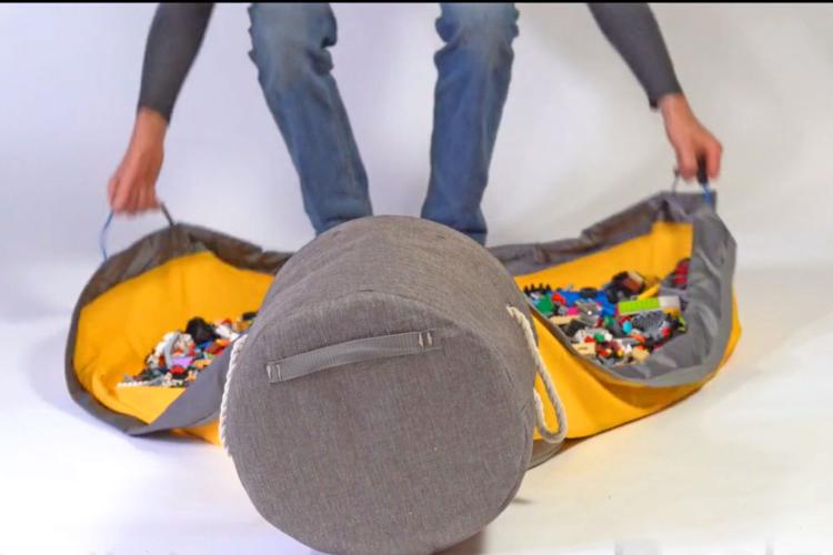 Gray and yellow bag with toys on a white background