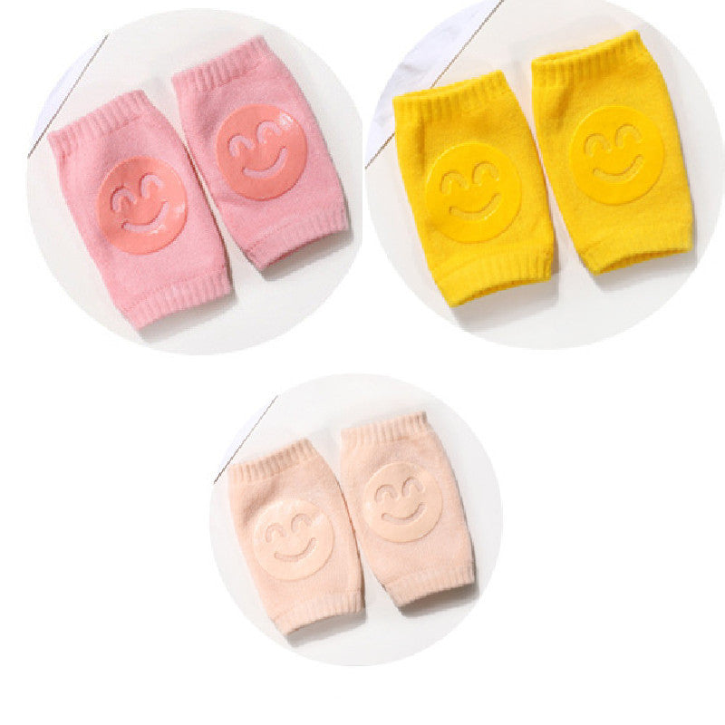 Set of four baby knee pads in pink, yellow, and peach on a white background
