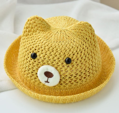 Yellow knit hat with a bear face design on a white background