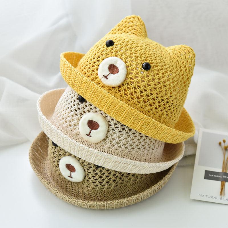 Three children's hats, one yellow, one cream and one brown, with bear face designs on a white background.