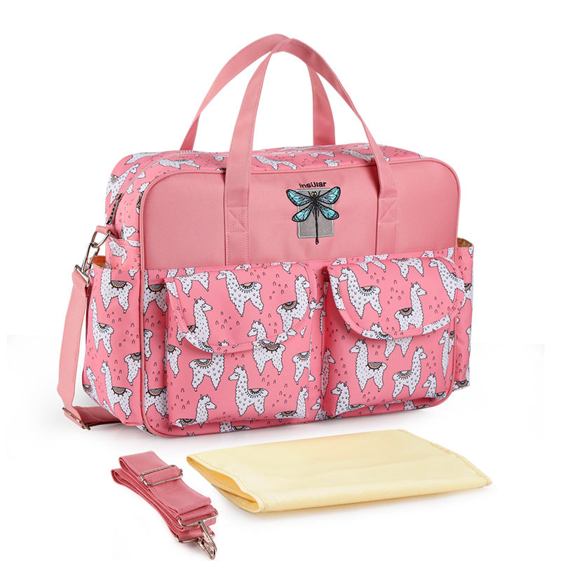 Pink diaper bag with animal pattern and accessories on a white background