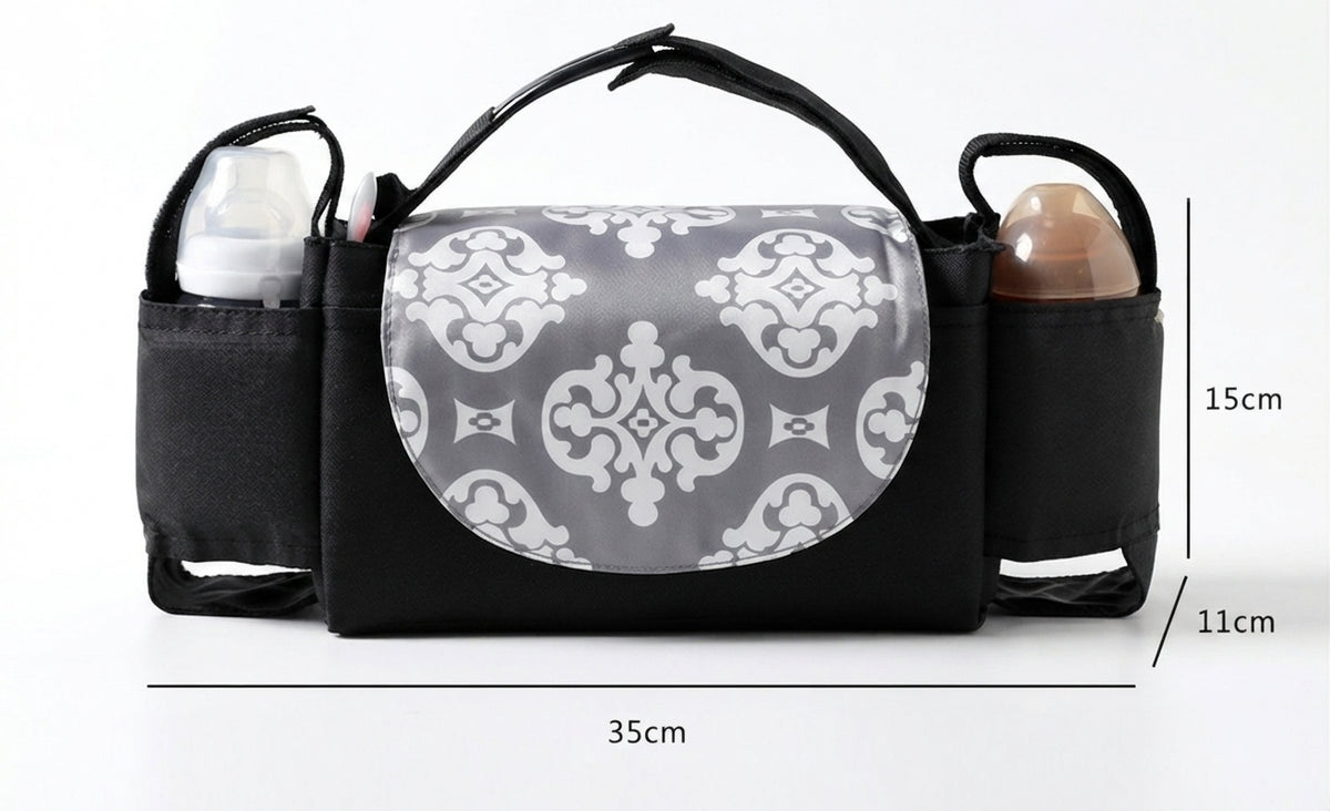 Black diaper bag organizer with a gray and white damask patterned front flap, shown with baby bottles in side pockets and dimension lines indicating 35cm width, 15cm height, and 11cm depth.