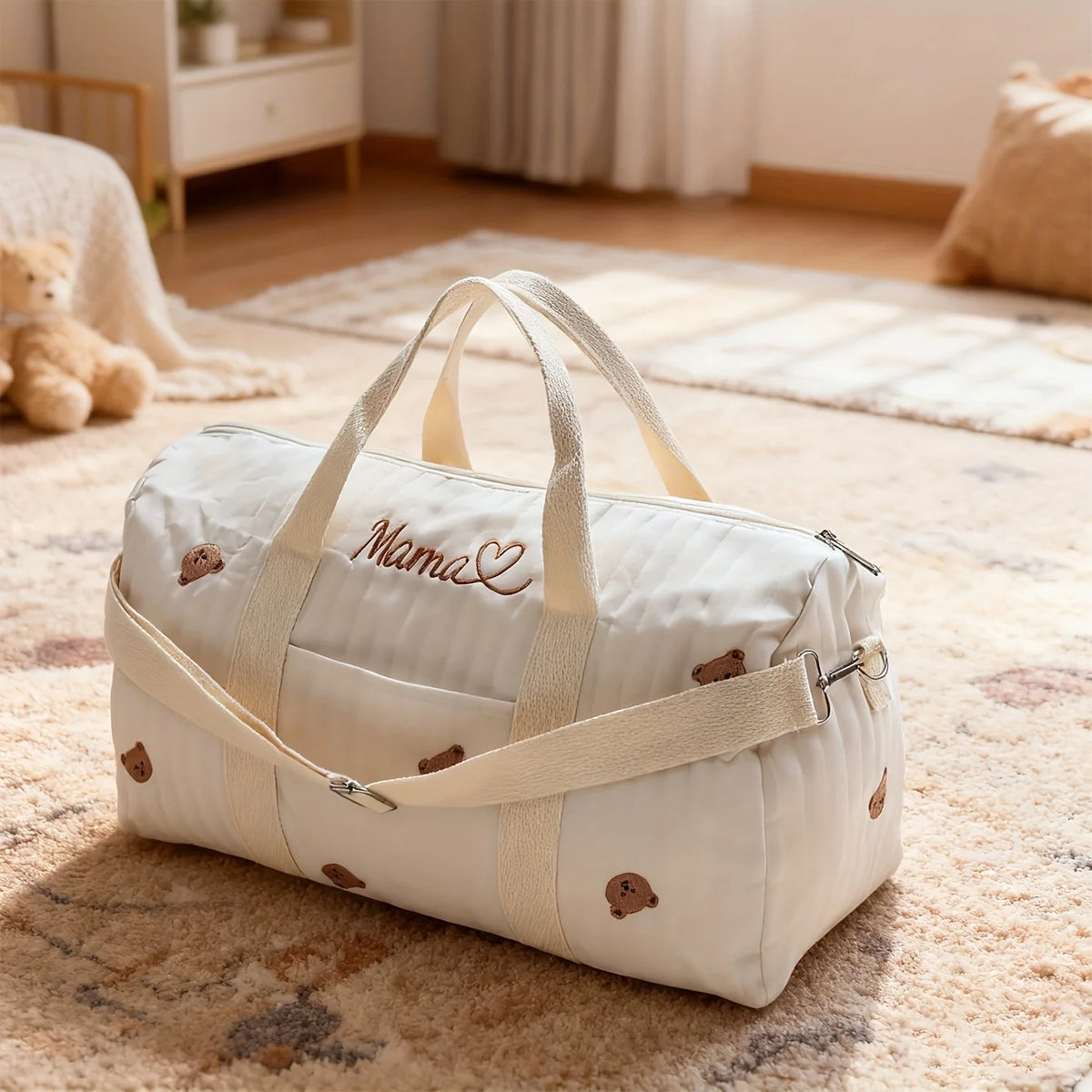 White baby bag with 'Mama' embroidery on a carpeted floor