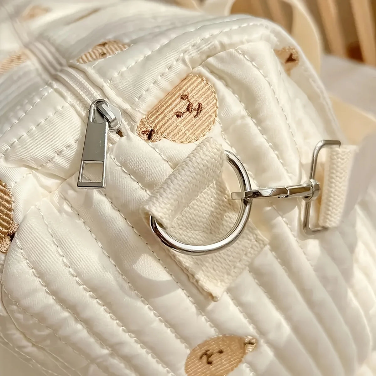 Close-up of a quilted handbag with gold accents and a silver clasp.