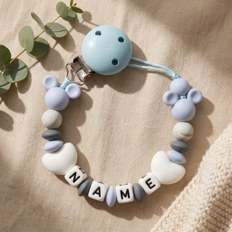 Baby teething ring with customizable name on a beige background