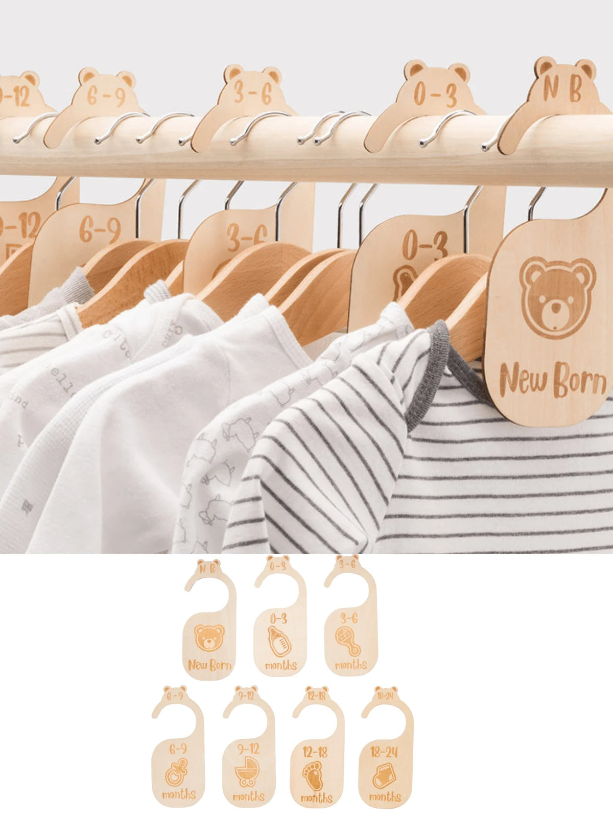 Baby clothes on wooden hangers with size labels and bibs displayed below.