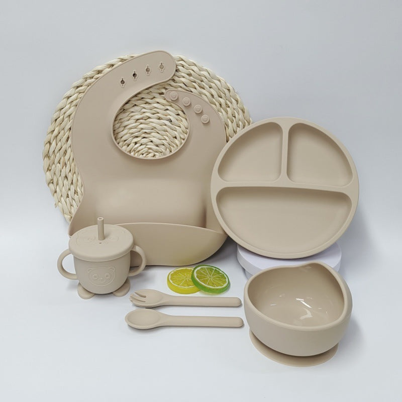 Beige ceramic tableware set including plate, bowl, mug, and utensils on a white background