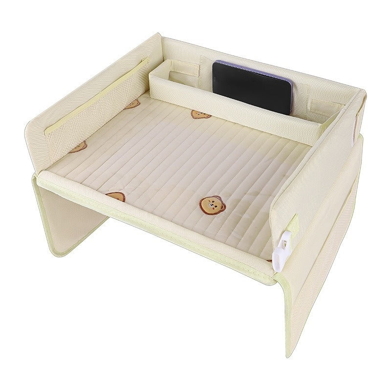 A cream-colored kids travel tray with a ribbed quilted surface and cute print, shown on a solid white background.